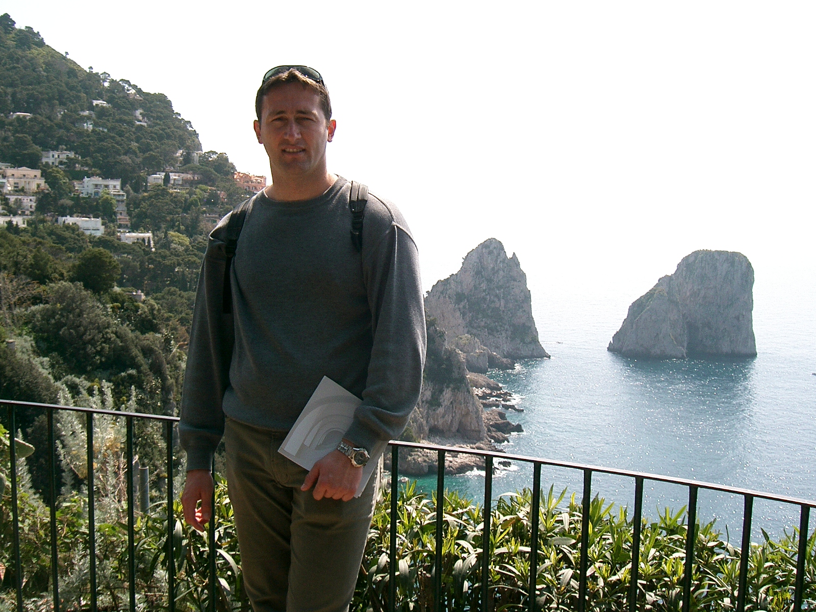 Visitor is taking picture at Augustus Gardens on Capri island with Faraglioni rocks in the background