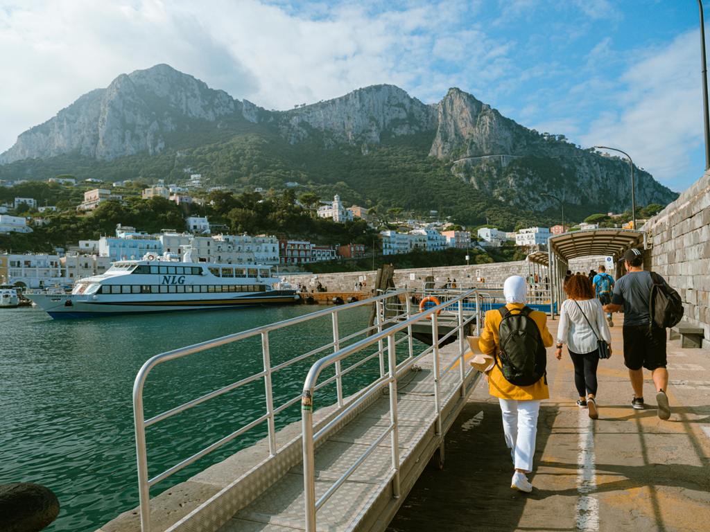 Passengers are walking along marina Grande Pier on Capri Island